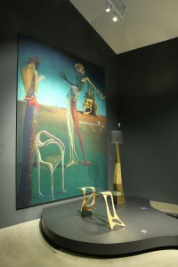 A blow-up of the painting Femme à la tête de roses by Salvador Dalí with Arabesco by Carlo Mollino and the lamp Bracelli by Salvador Dalí, as seen at Objects of Desire. Surrealism and Design 1924 - Today, Vitra Design Museum