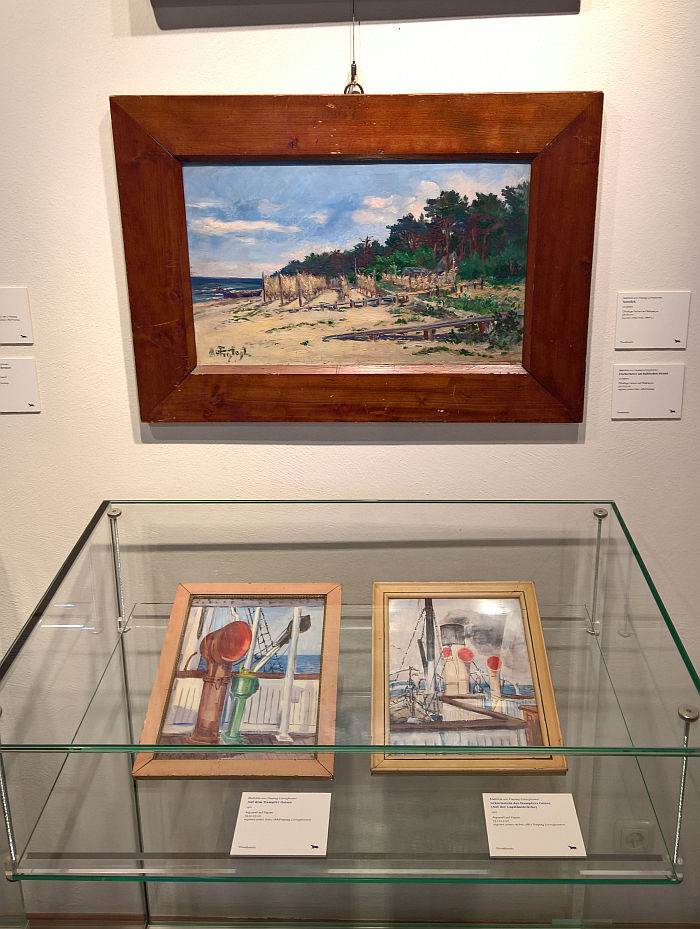 Water colours of a ship's cowls and an oil painting of a Baltic Sea beach, all by Mathilde von Freytag-Loringhoven, as seen at Mathilde von Freytag-Loringhoven. Painter, Author, Animal, Psychologist and Bauhaus Critic, Stadtmuseum Weimar