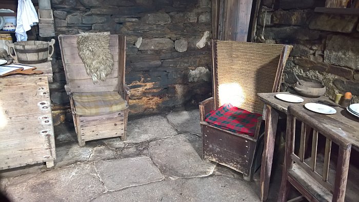 A cold and damp and draughty and occasionally sunlight croft. A straw-backed chair and a wooden backed chair. As seen at Kirbuster Museum Orkney, and thus a recreated scene.