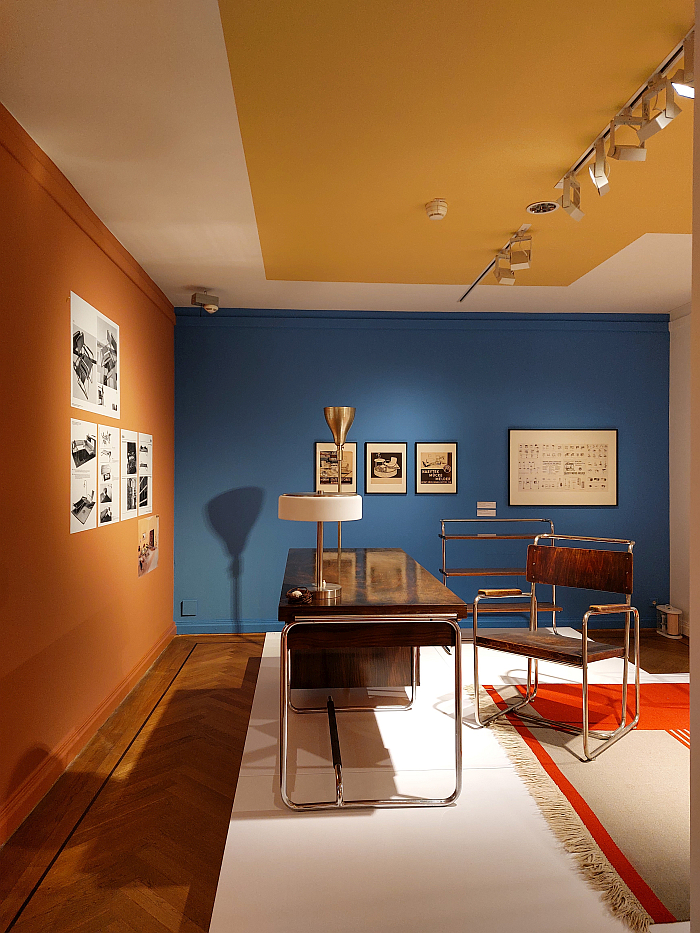 A chair by Karel E. Ort for, and an in-house desk from, Hynek Gottwald, alongside a lamp by Jaroslav Anýž and numerous steelt ub furniture manufacturers catalogues, as seen at Hej rup! The Czech Avant-Garde, Bröhan Museum, Berlin
