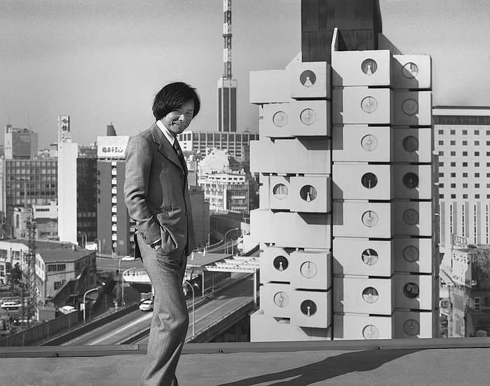 Kishō Kurokawa in front of the completed Nakagin Capsule Tower, 1974, part of The Many Lives of the Nakagin Capsule Tower", the Museum of Modern Art, New York (Photo: Tomio Ohashi, courtesy Museum of Modern Art, MoMA, New York)