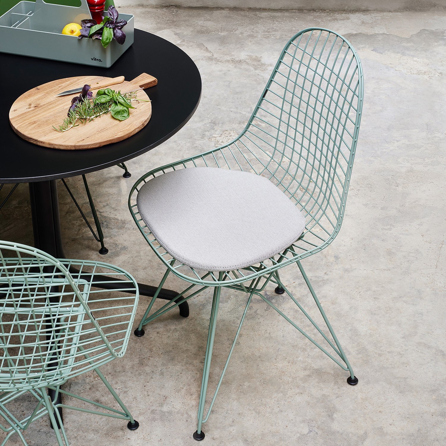 Wire Outdoor Stuhl von Vitra auf einer Terrasse an schwarzem Tisch