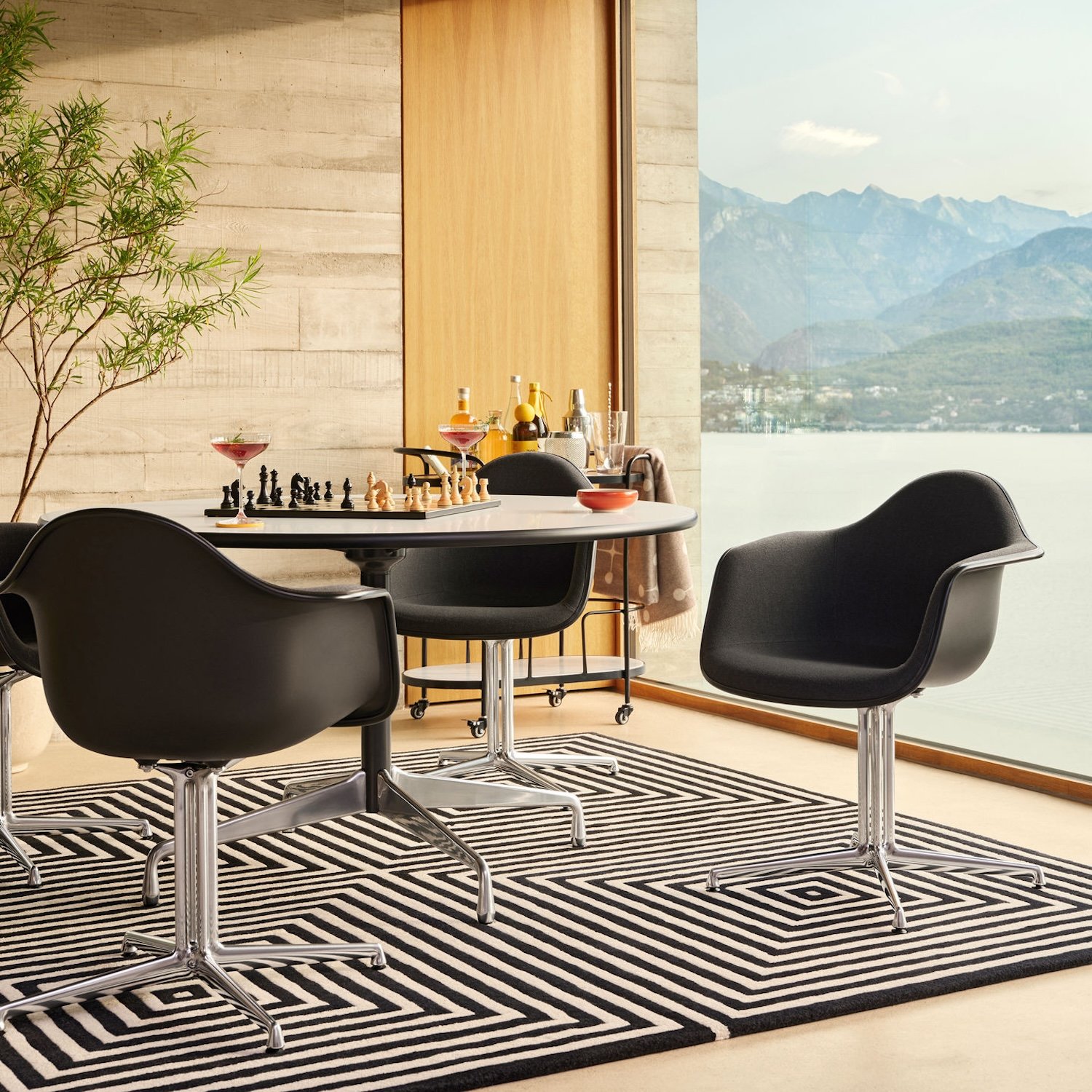 Eames Plastic Armchair DAL vor Fenster mit Bergpanorama